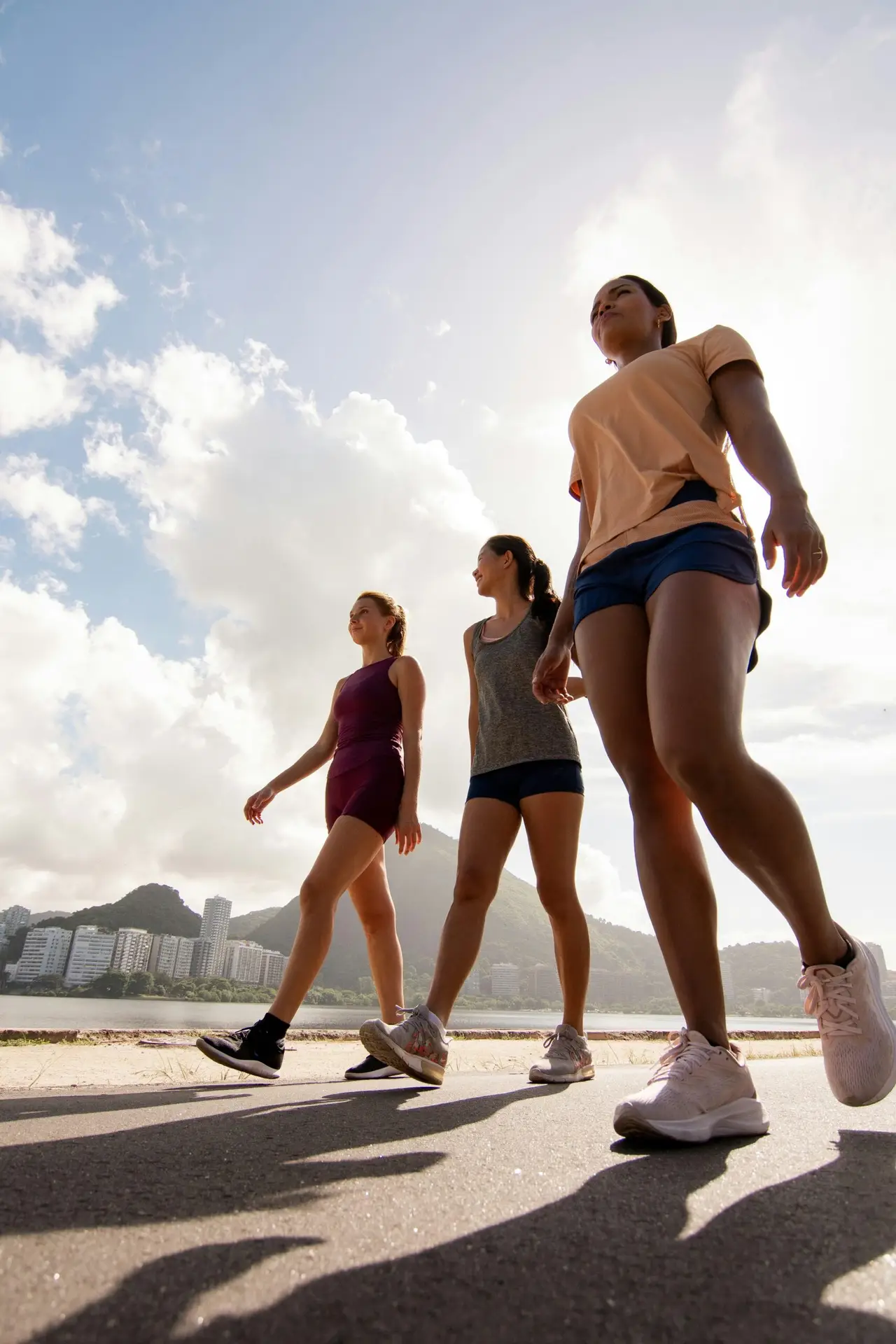 Three women out walking together under a bright sky
