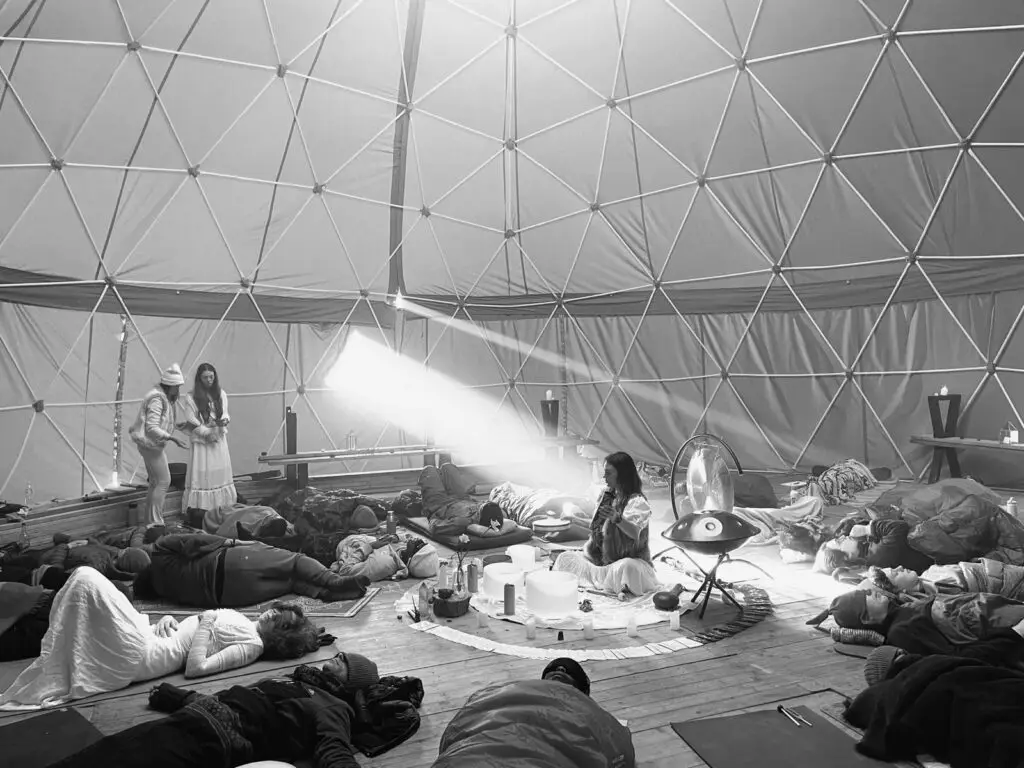 People lying in a geodesic dome during a sound bath