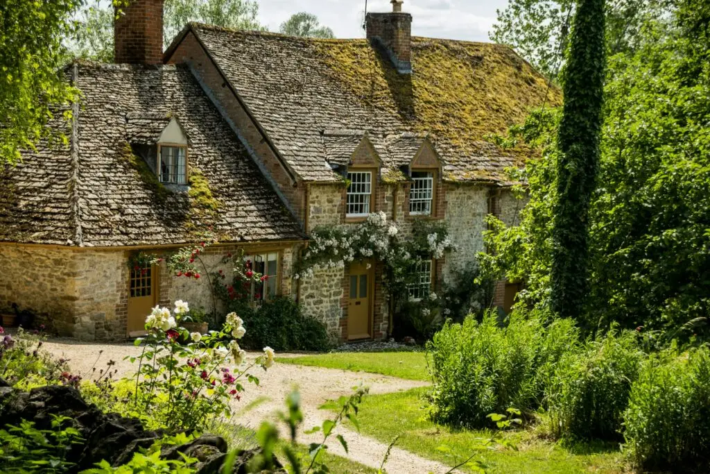 A stone cottage in the Cotswolds, surrounded by a green garden
