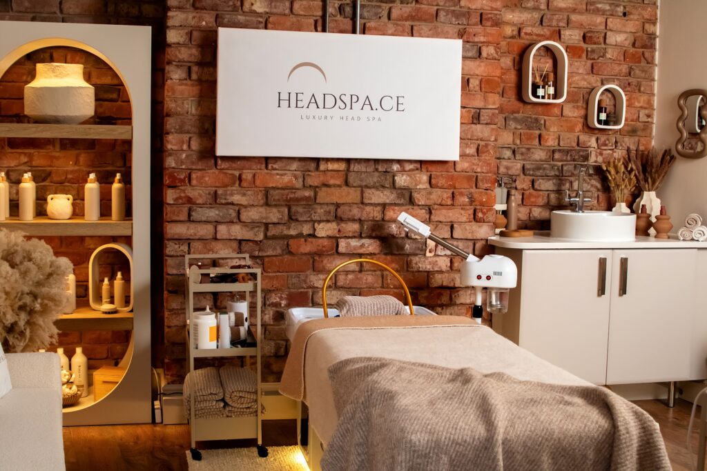 The treatment room at Headspa.ce in Alderley Edge, with a brick wall and warm shelving
