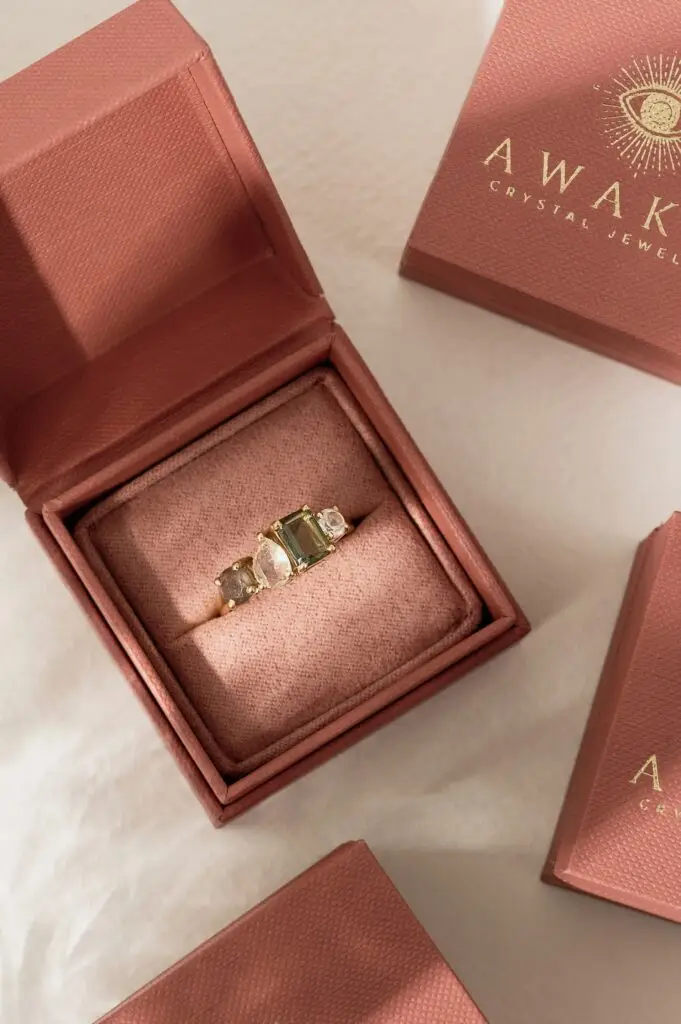 An Awaken crystal ring in a rose pink presentation box