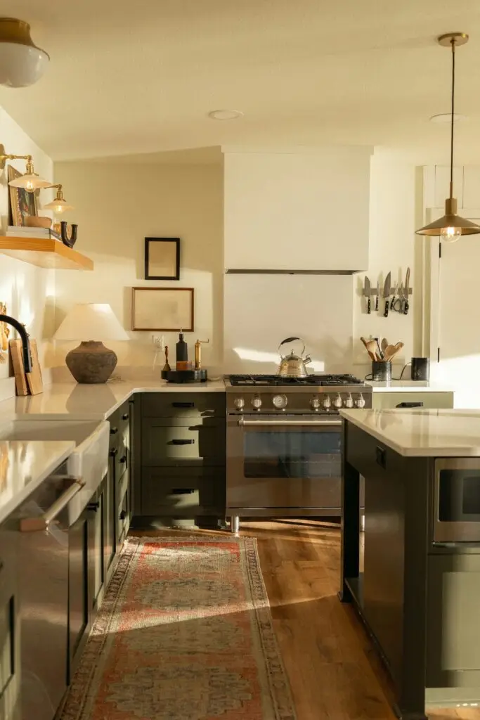 A warm, light-filled kitchen with dark green cabinets, a range cooker and a vintage runner