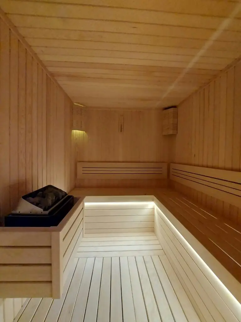 A softly lit wooden sauna with tiered benches