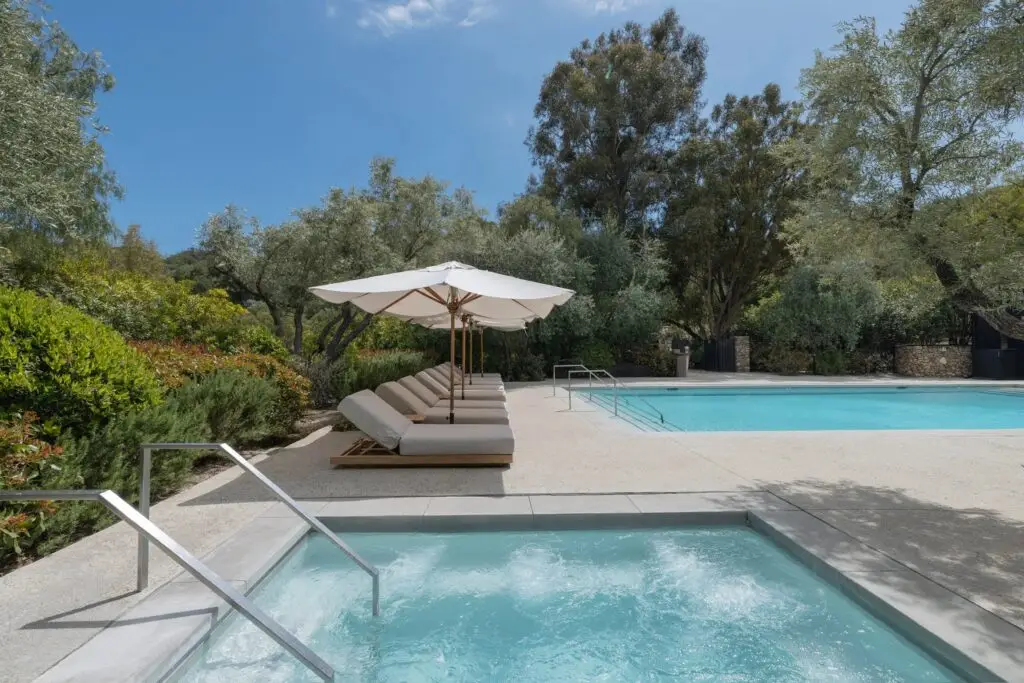 A plunge pool and sun loungers among the gardens at The Ranch Malibu