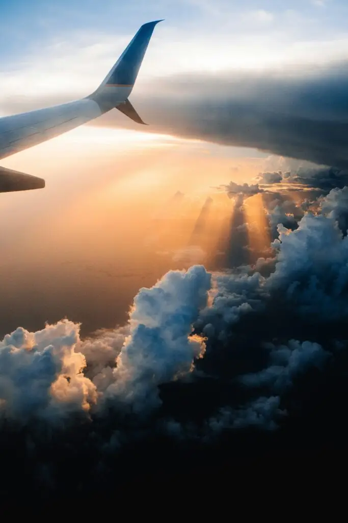 The view from a plane window over clouds at sunset