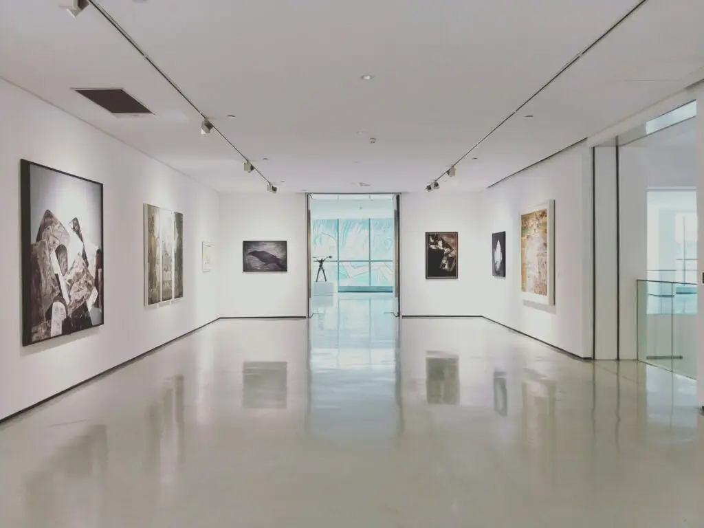 A bright white gallery hung with paintings
