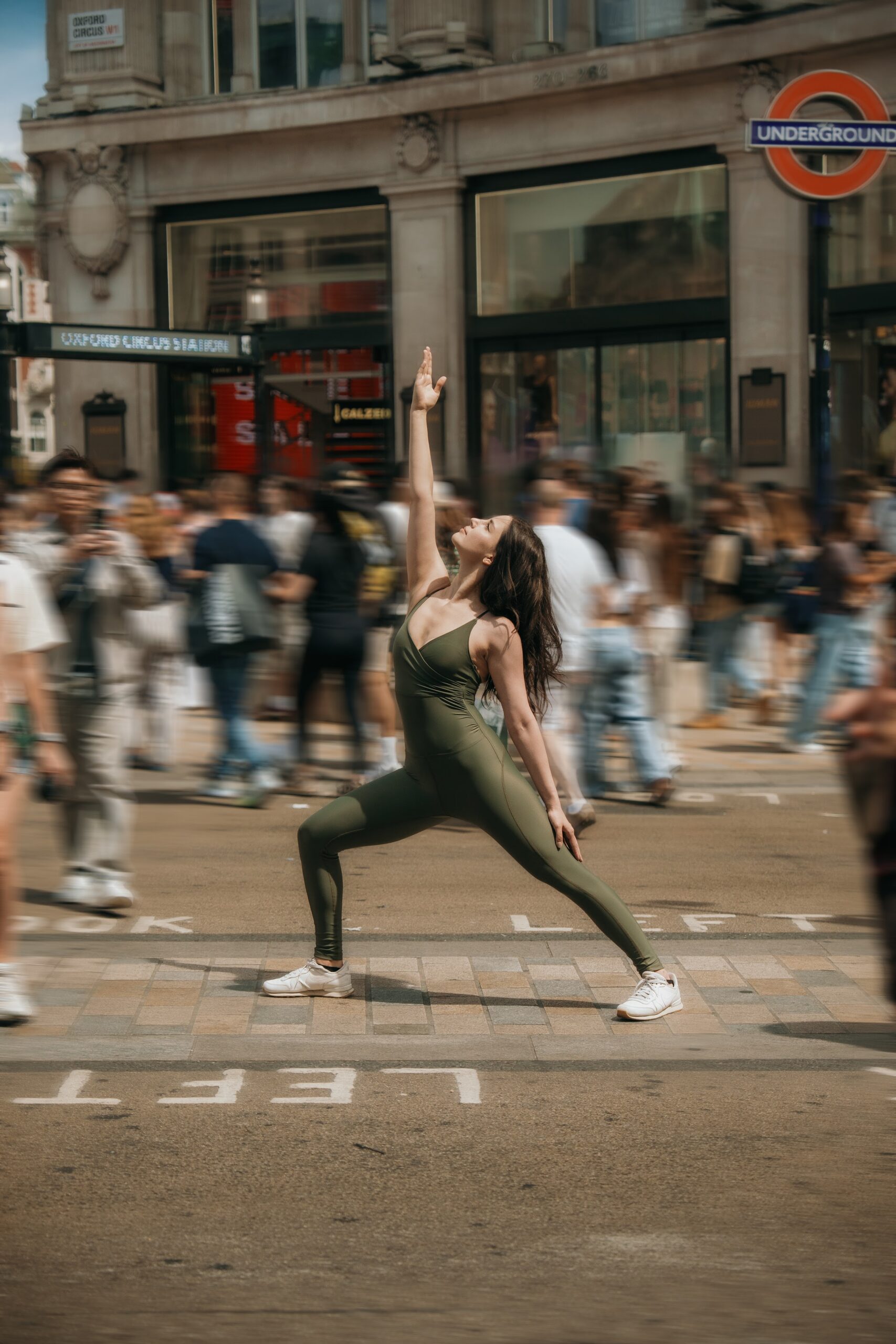 A dancer mid-movement in the middle of a busy London street outside Oxford Circus